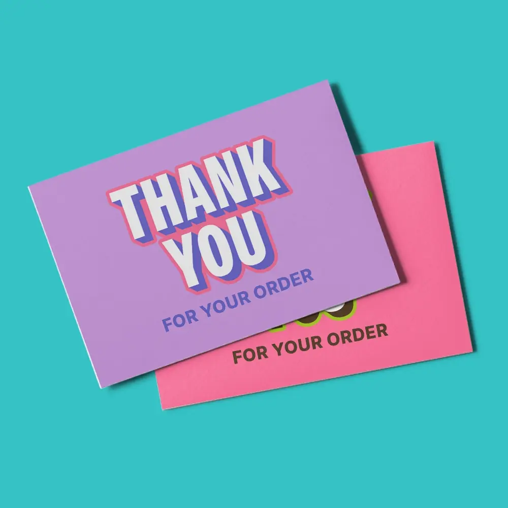 Two Postcards reading "thank you for your order", photographed on a turquoise backdrop. 