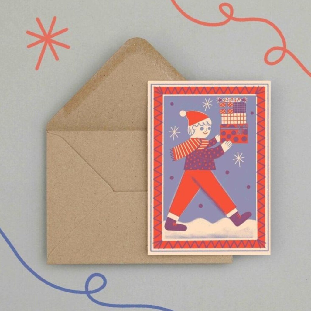 A cartoon red and blue christmas card of a boy carrying presents in the snow