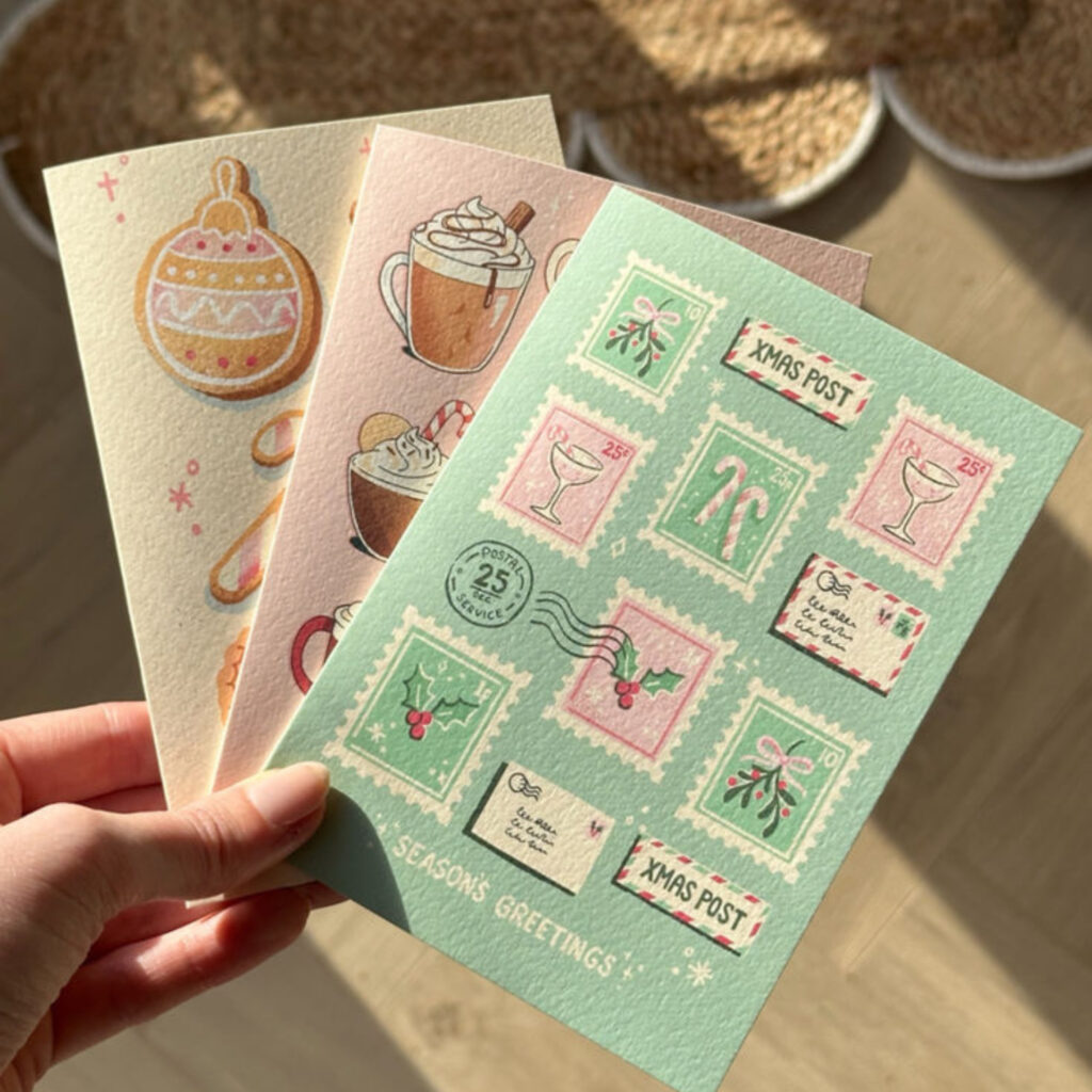 three different Christmas cards in pastel yellow, pink and green