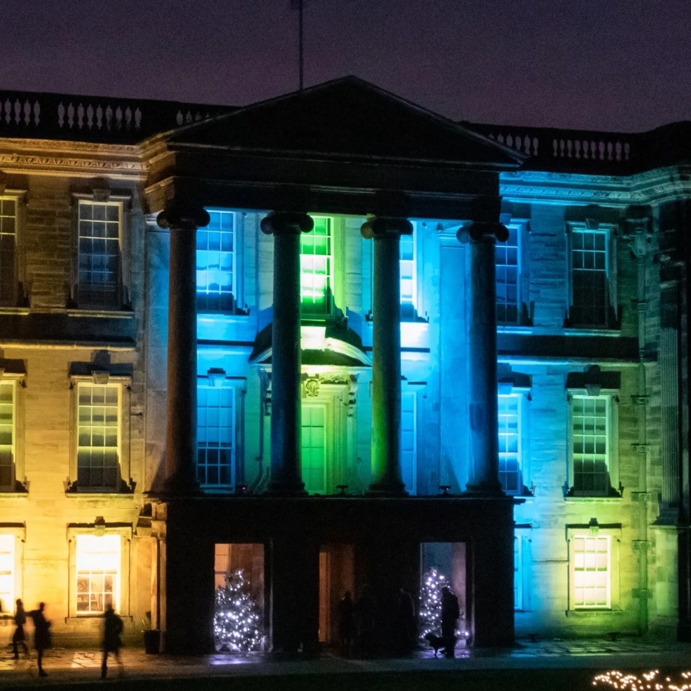 Calke Abbey in Derbyshire lit up in Christmas lights at night. 