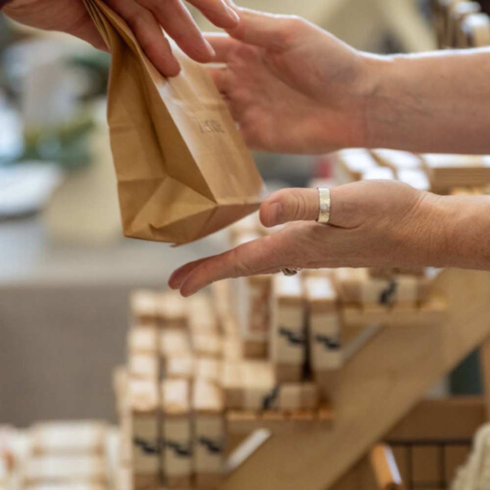 A customer being handed a small paper bag after making a purchase at Yarm Christmas Market.