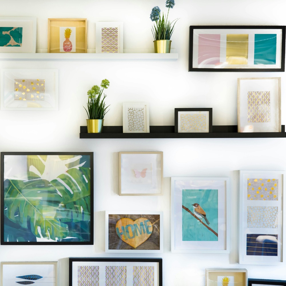 A gallery wall featuring various prints, illustrations and photographs.