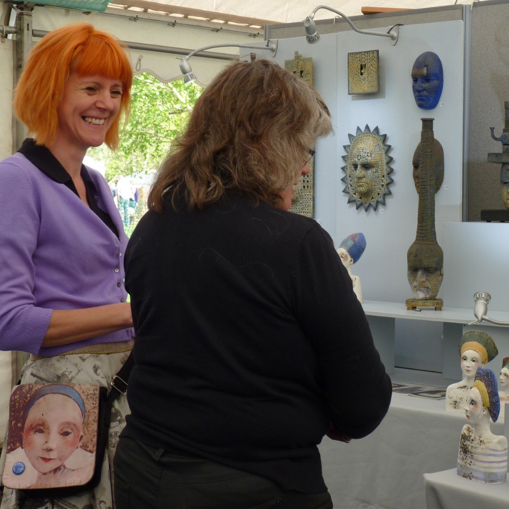 Two exhibitors smiling at their craft stall.