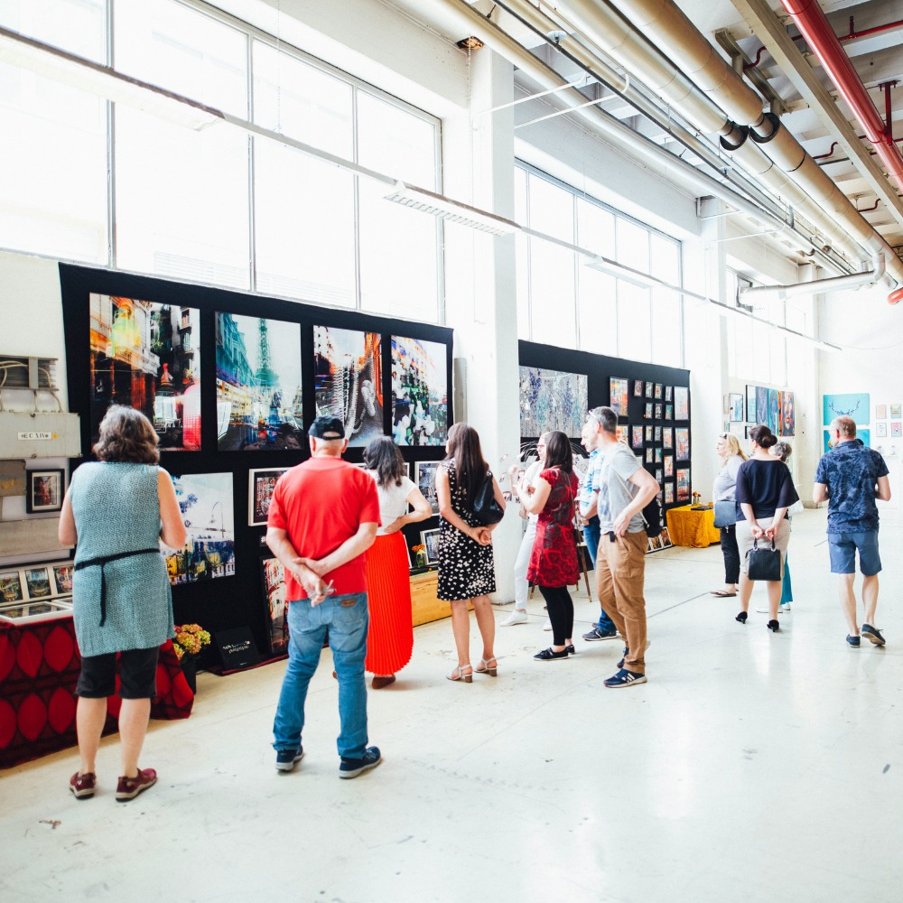 People perusing artwork at an art fair.