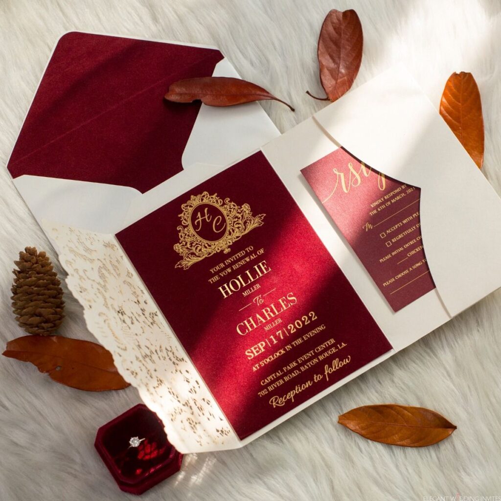 Burgundy Wedding Invitation in a cream coloured envelope, photographed by autumnal leaves. 