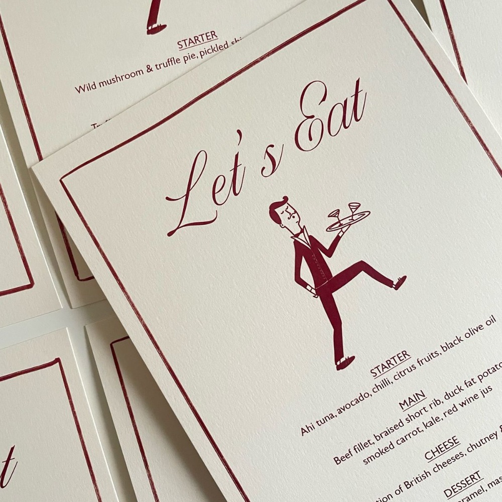 A cream Wedding Menu with burgundy lettering and a quirky illustration of a waiter carrying drinks on a tray. 