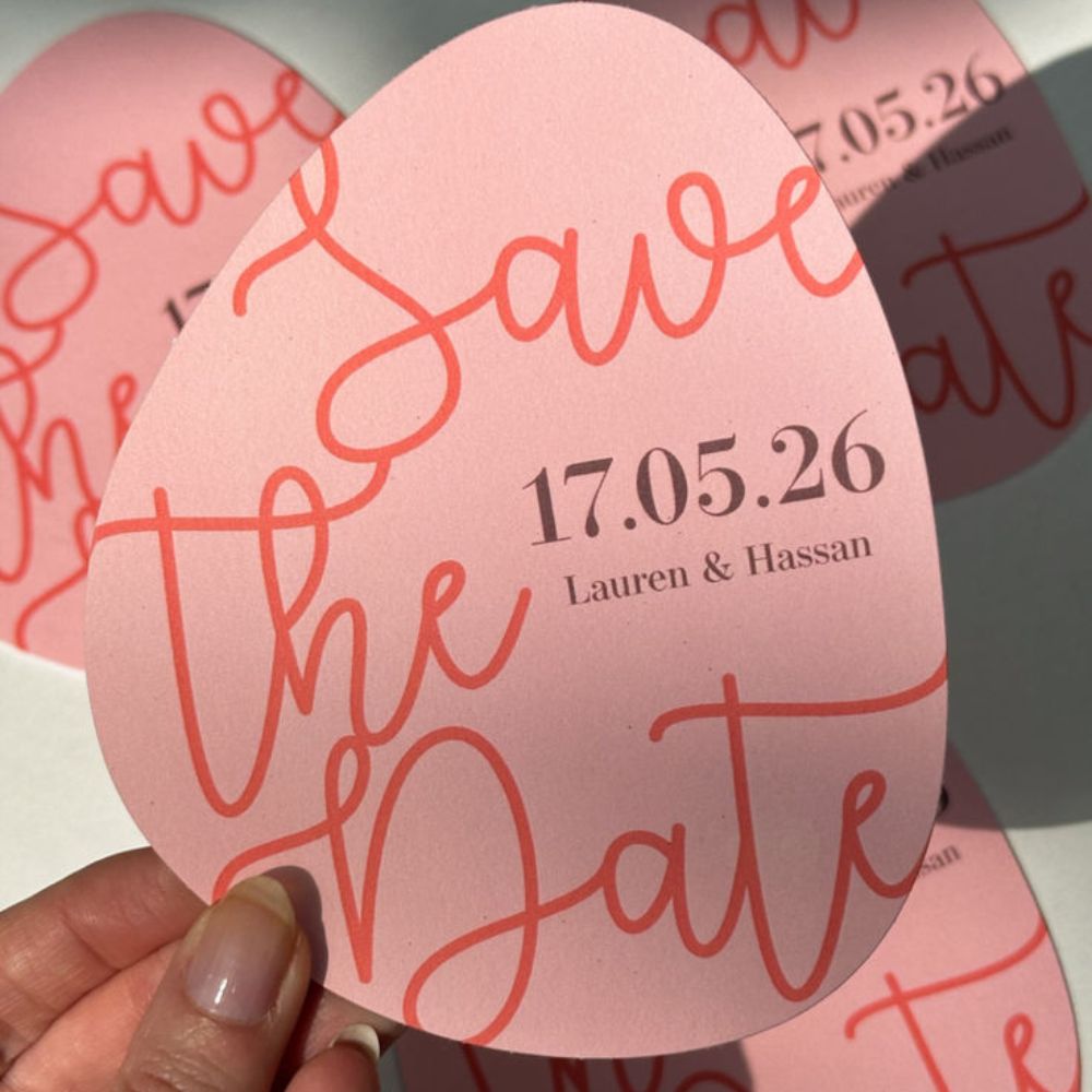 A pebble shaped Save the Date with handwritten details. 