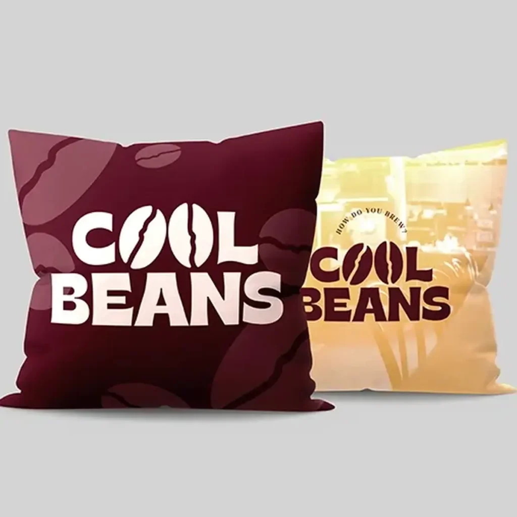 Two Branded Cushions reading "Cool Beans". The one in the foreground is Burgundy the one in the background is a cream colour.