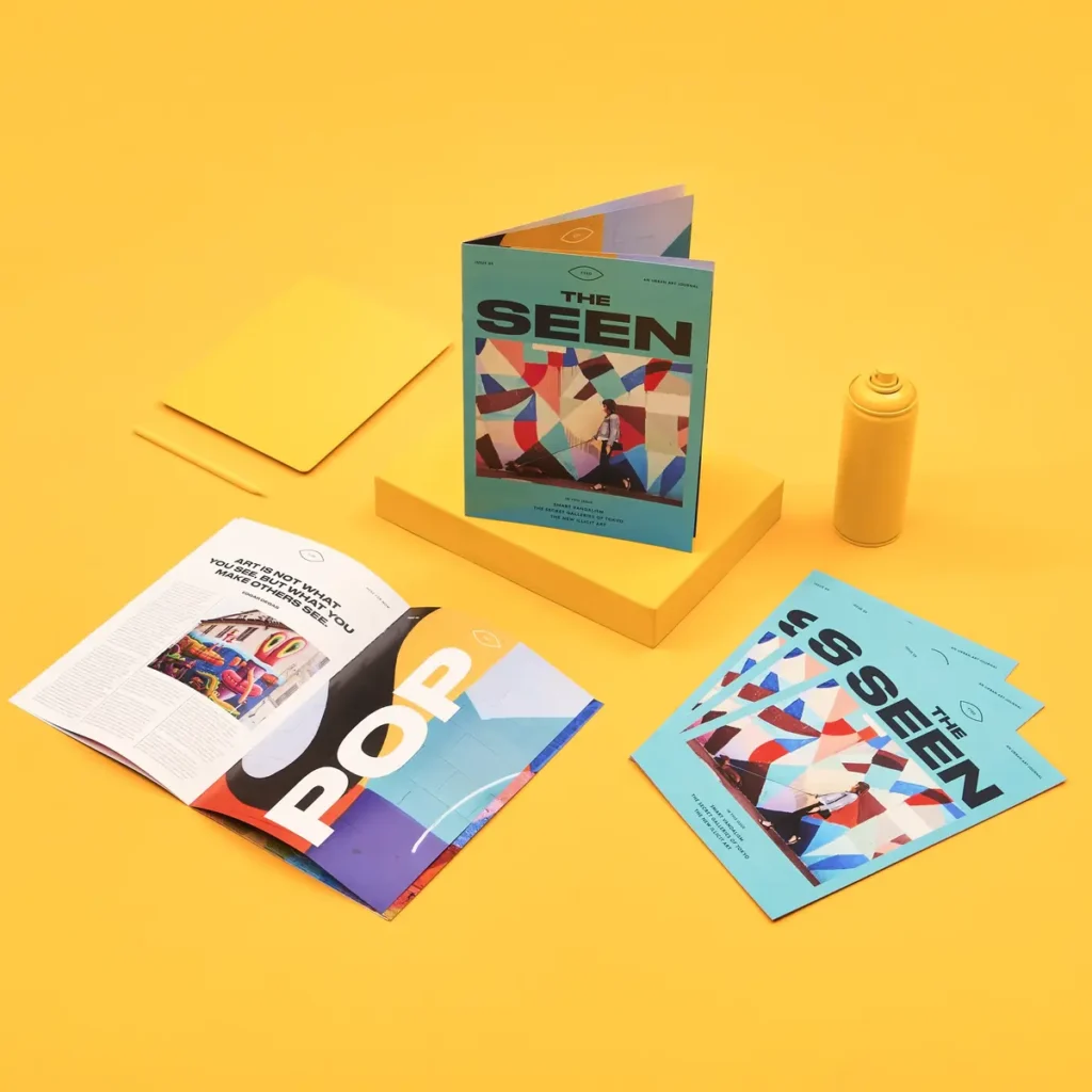 Three Saddle Stitched Brochures for "The Seen" magazine, photographed on a yellow background. 