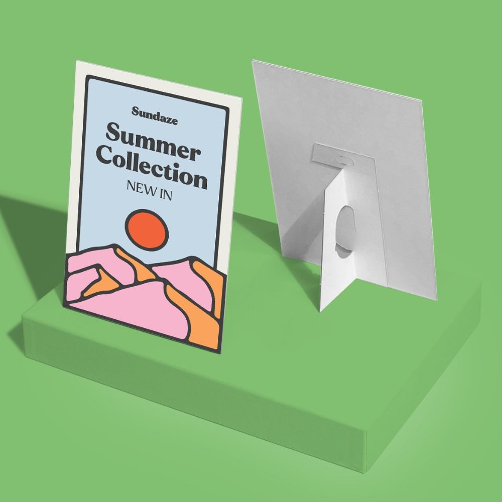 Strut Card with a design advertising Sundaze's Summer Collection. Photographed on a green background. 