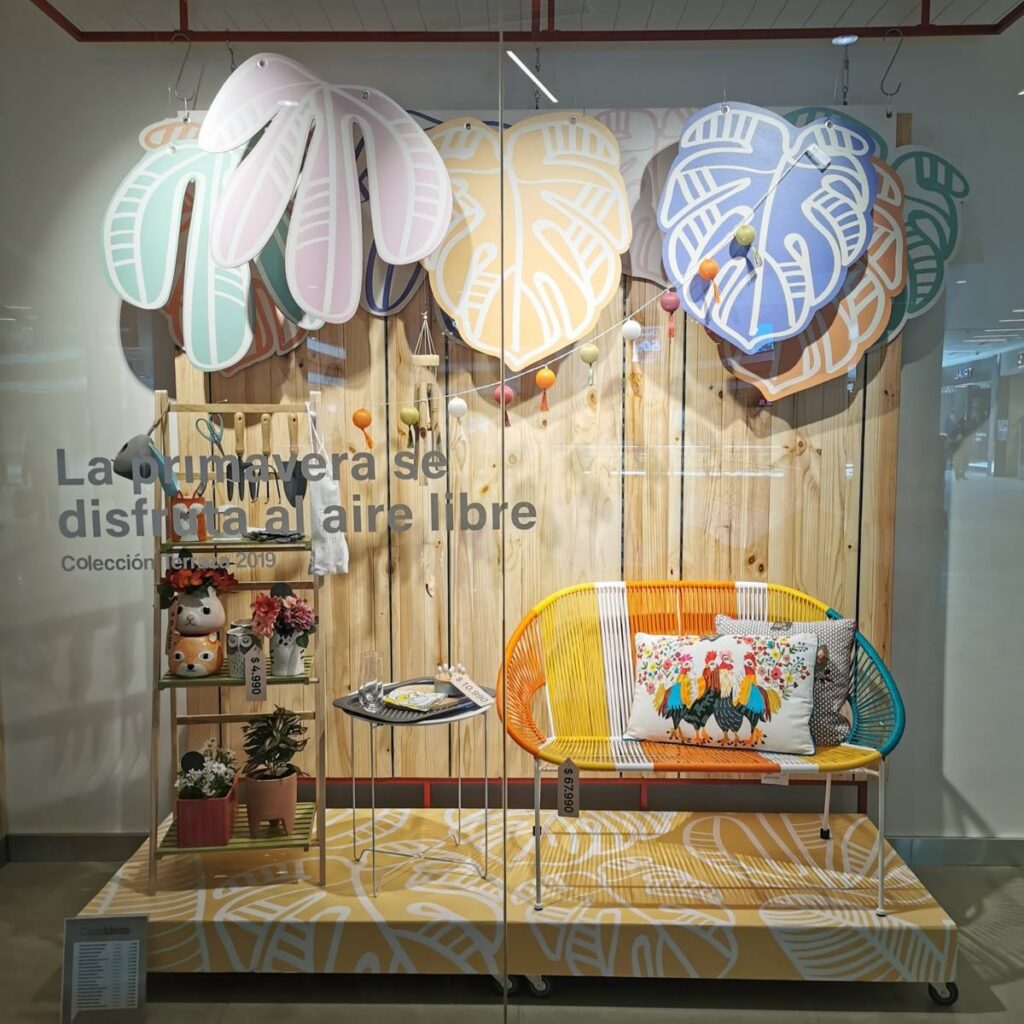 Window display featuring furniture and display boards in a leaf design.