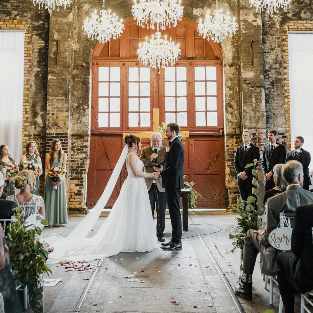 A couple holding hands during their wedding ceremony. 