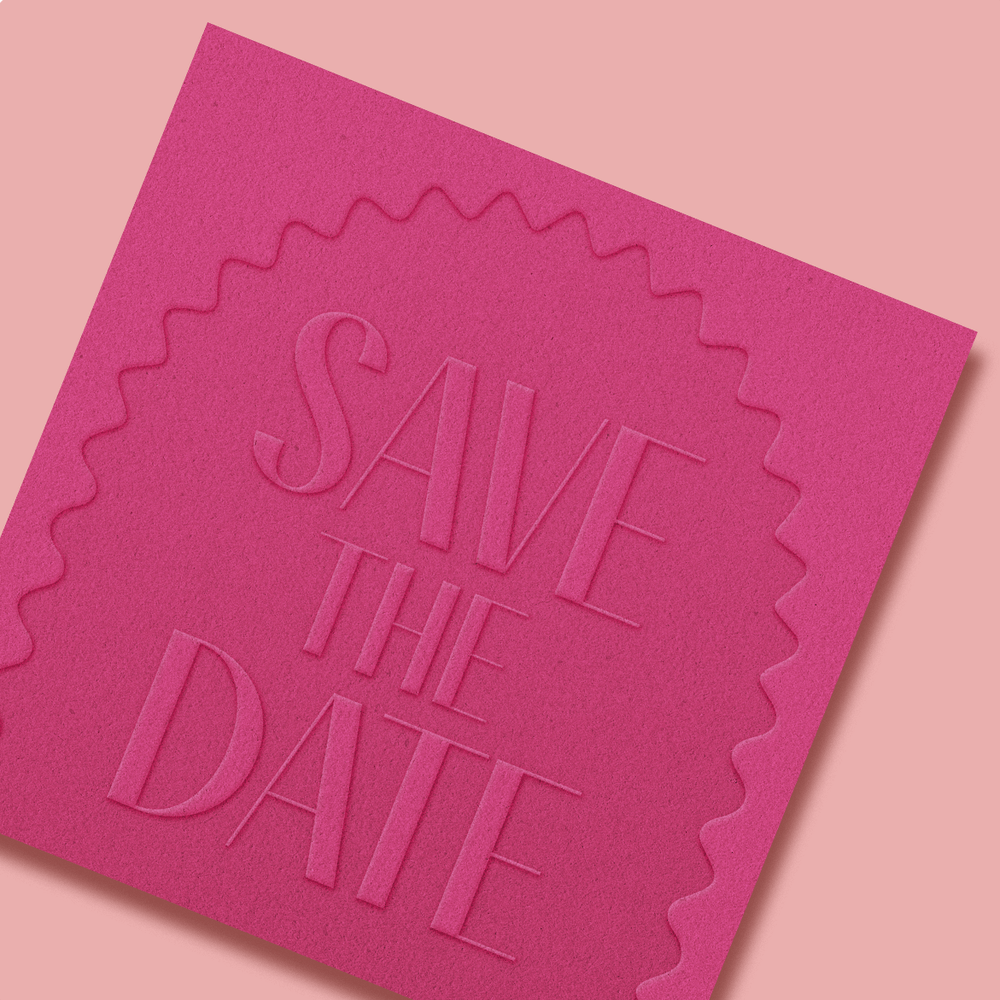 An Embossed Save the Date on a dark pink paper. 