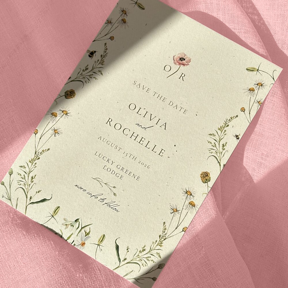 Olivia and Rochelle's Save the Dates, featuring flower motifs and photographed on a pink background.