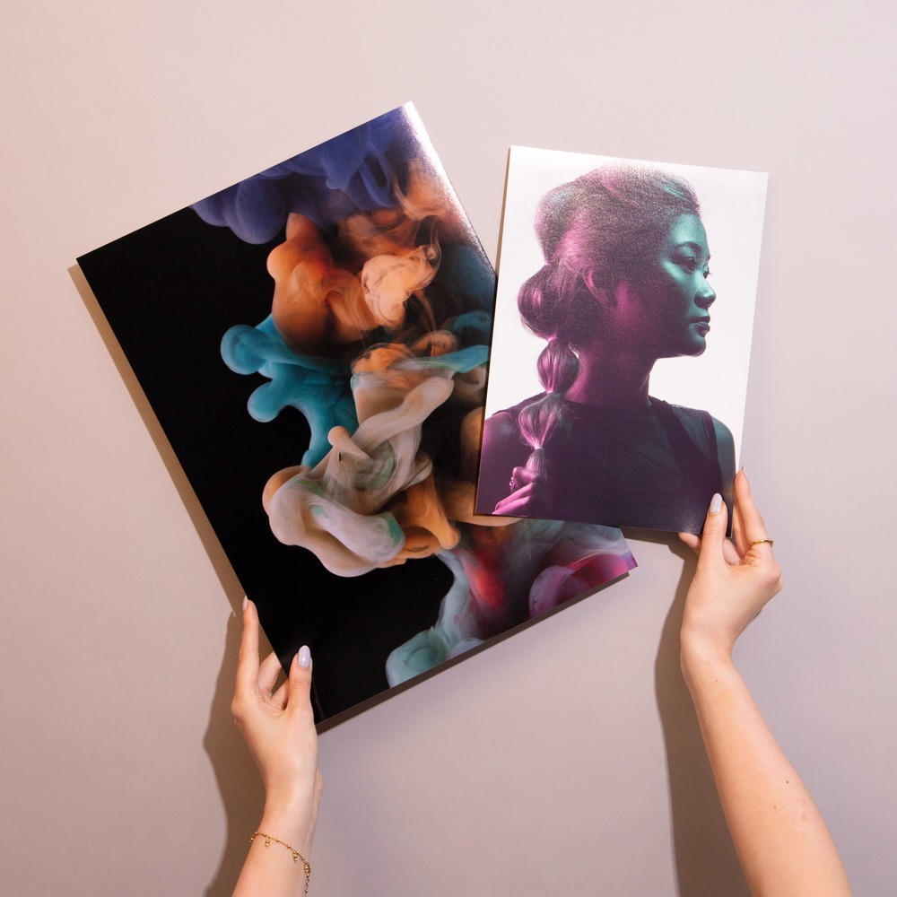 Two Giclée prints being held side by side.