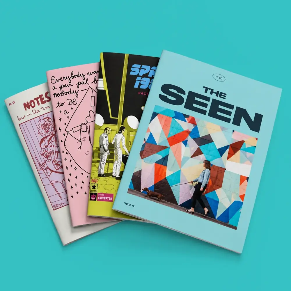 Four Zines photographed against a turquoise background.