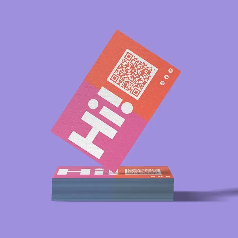 A pink and orange Business Card, photographed on a purple background.