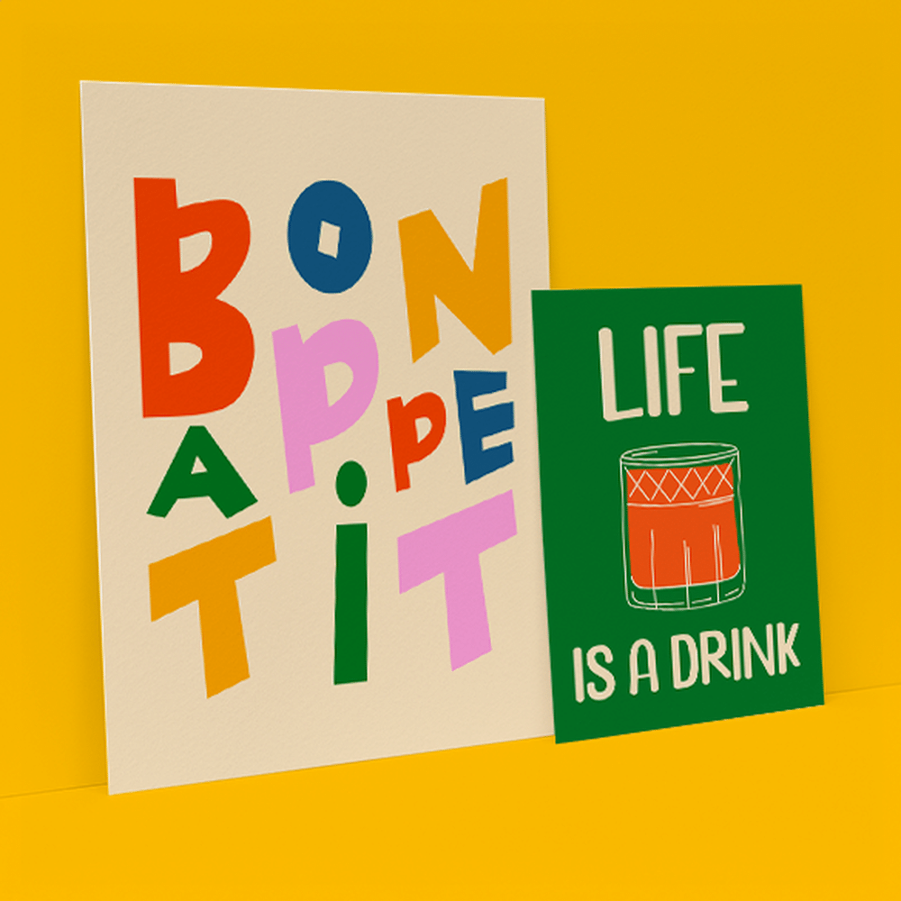 Two Giclée Prints side by side on a yellow background, one says 'bon appetit' the other says 'life is a drink'.