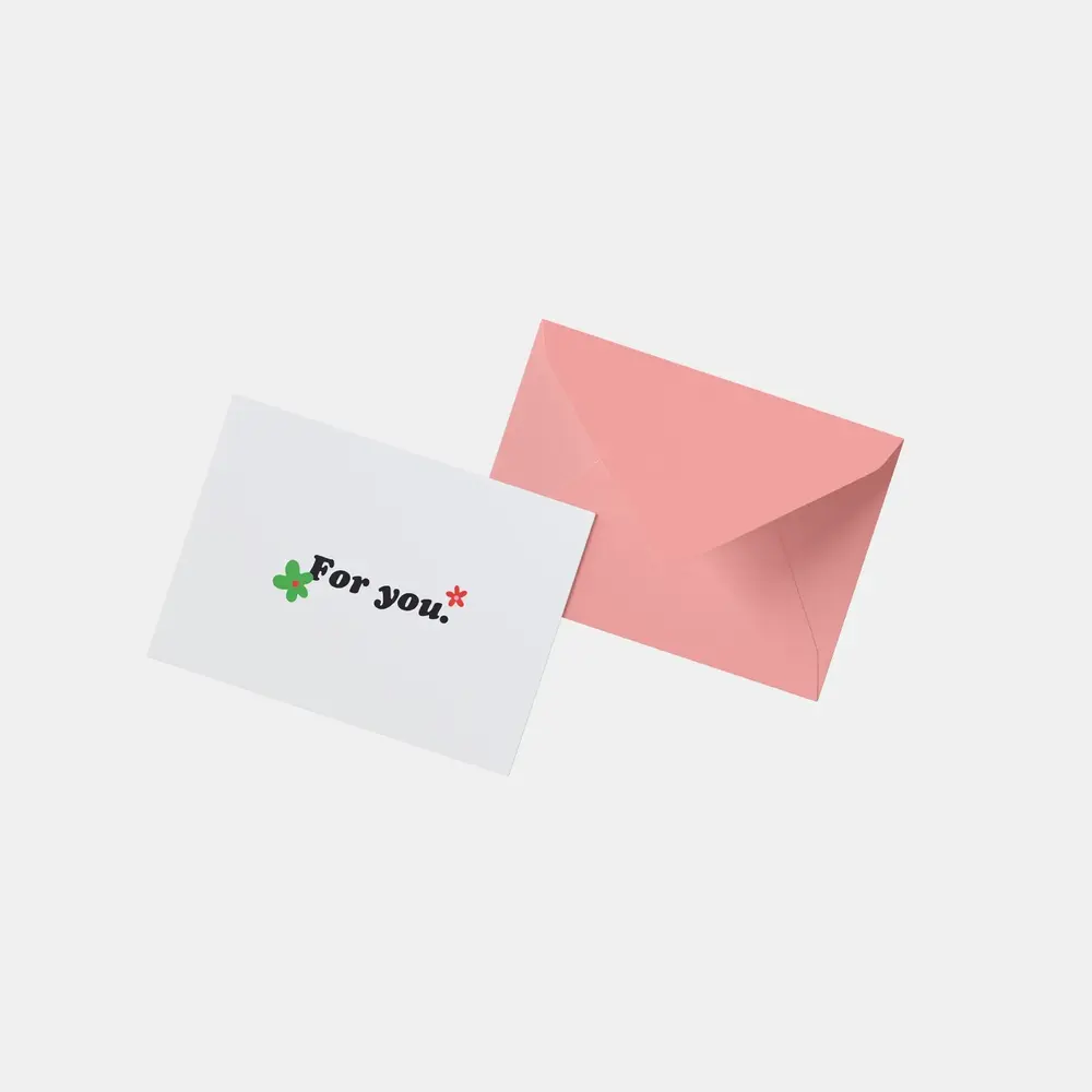 A pink Envelope with a white Postcard saying "for you" with two flowers. 