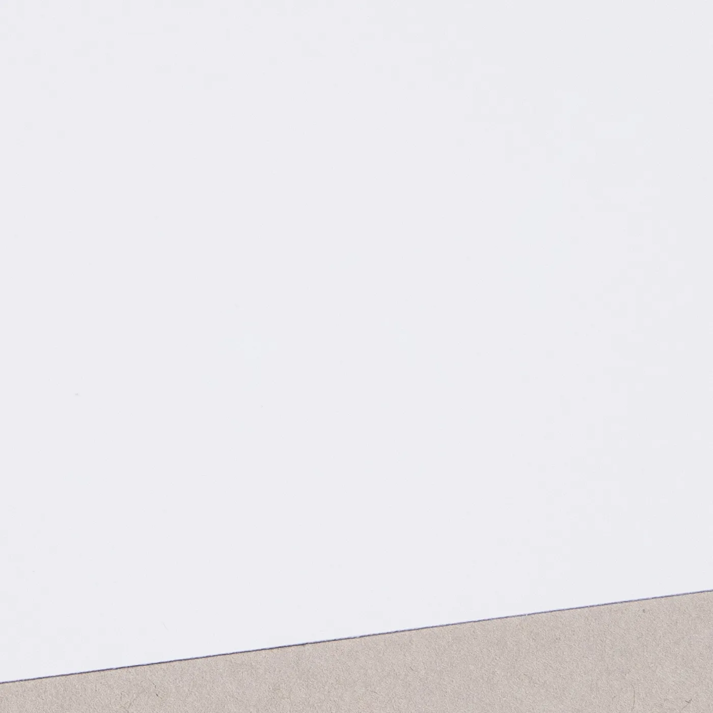 Flat white paper at an angle with a neutral background.