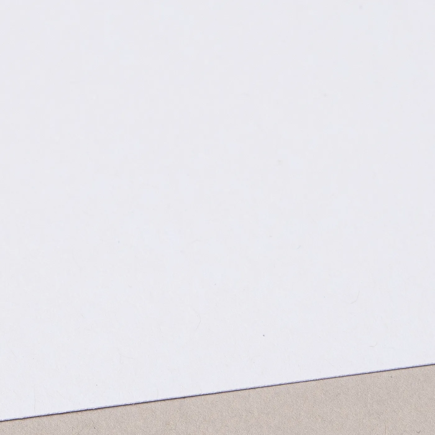 Close-up of a recycled uncoated card with natural fiber details.
