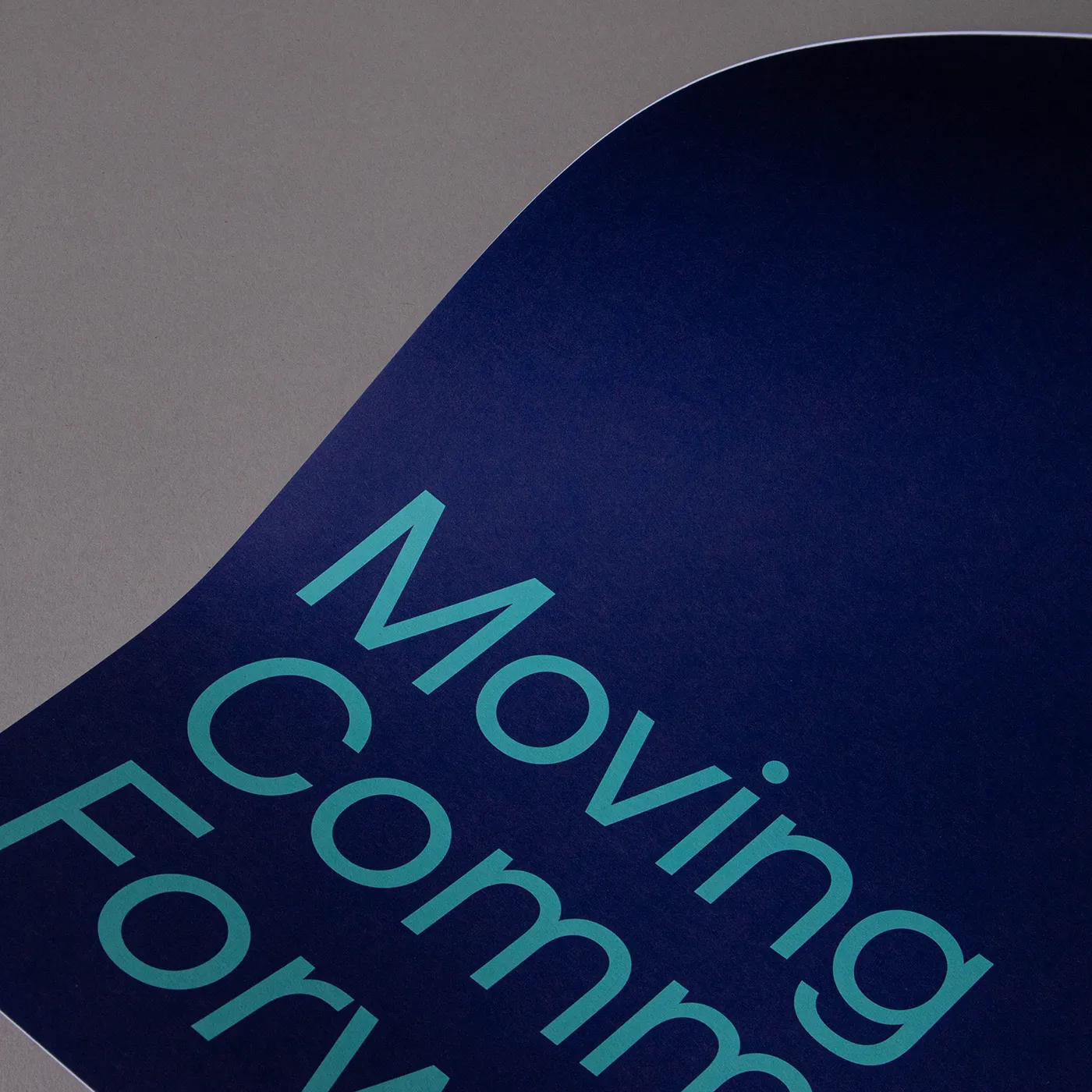 Close view of a recycled card's edge and uncoated surface with a dark blue design.