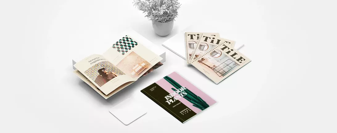 Selection of booklets and catalogs laid out on a workspace