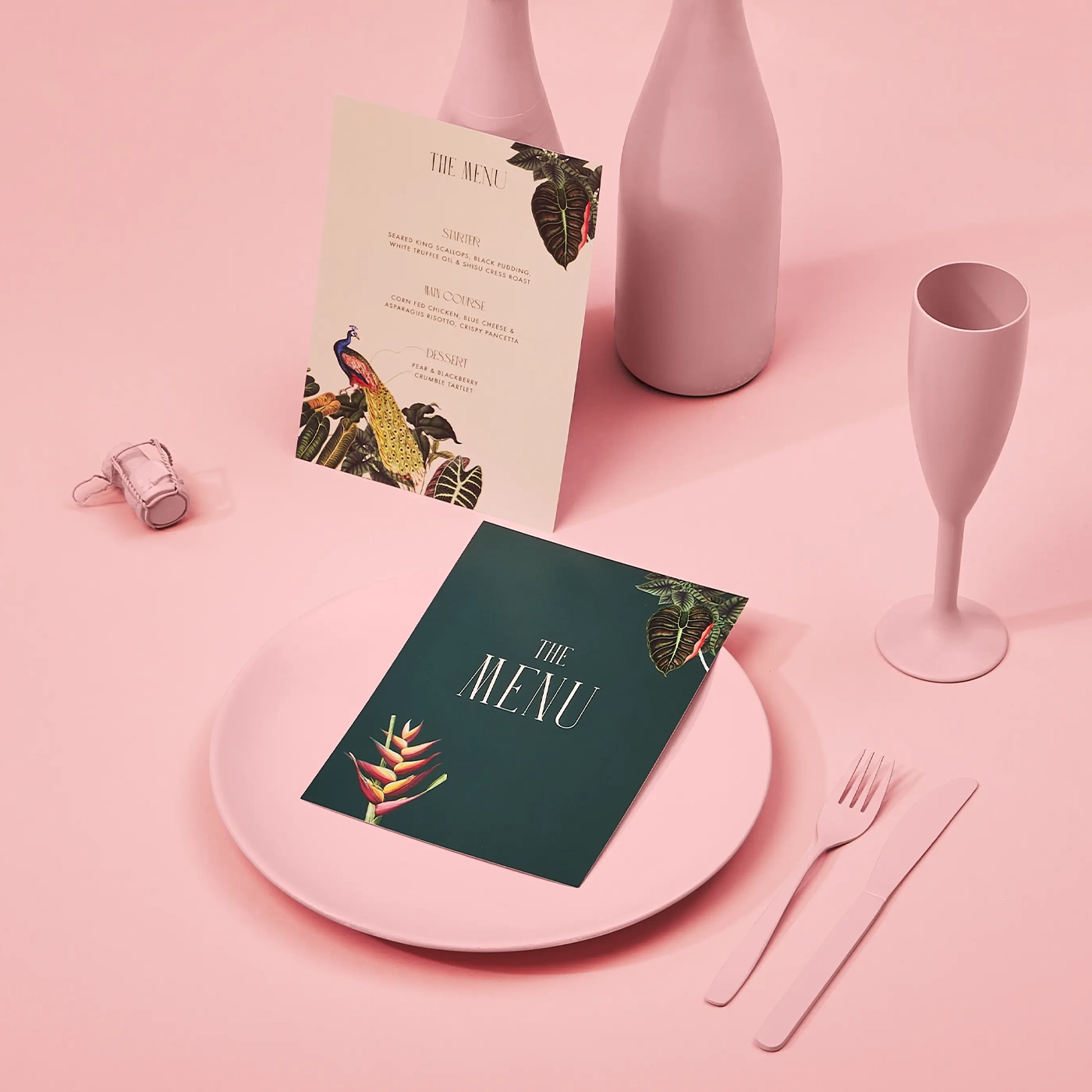 Wedding stationery menus laid out on a pink table setting