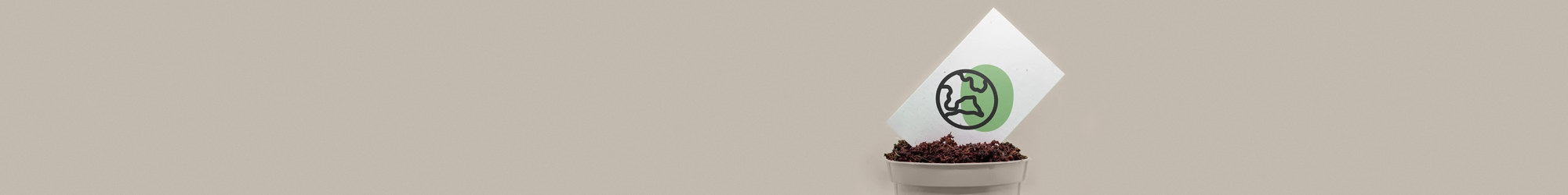 A single business card printed with a black and green earth icon, placed on an angle in the top of a plant pot containing soil.