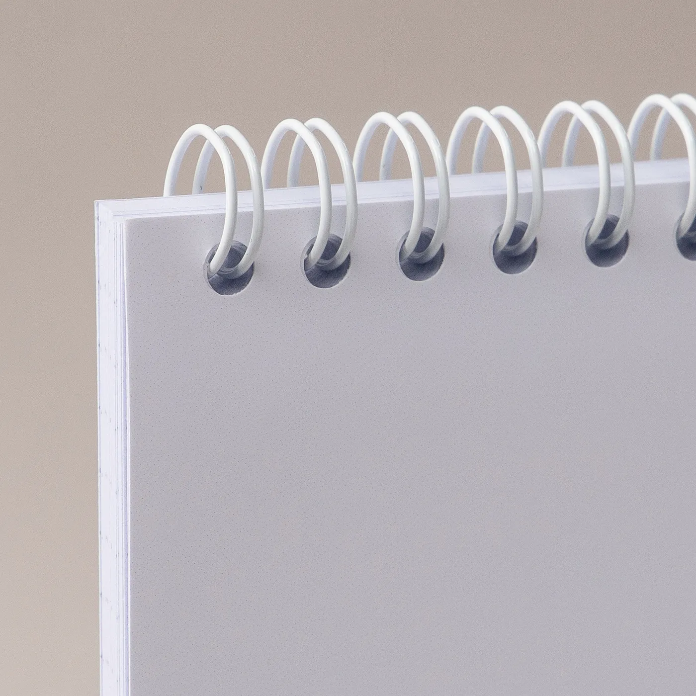 White spiral wire binding shown in a plain paper book on a plain gray background.