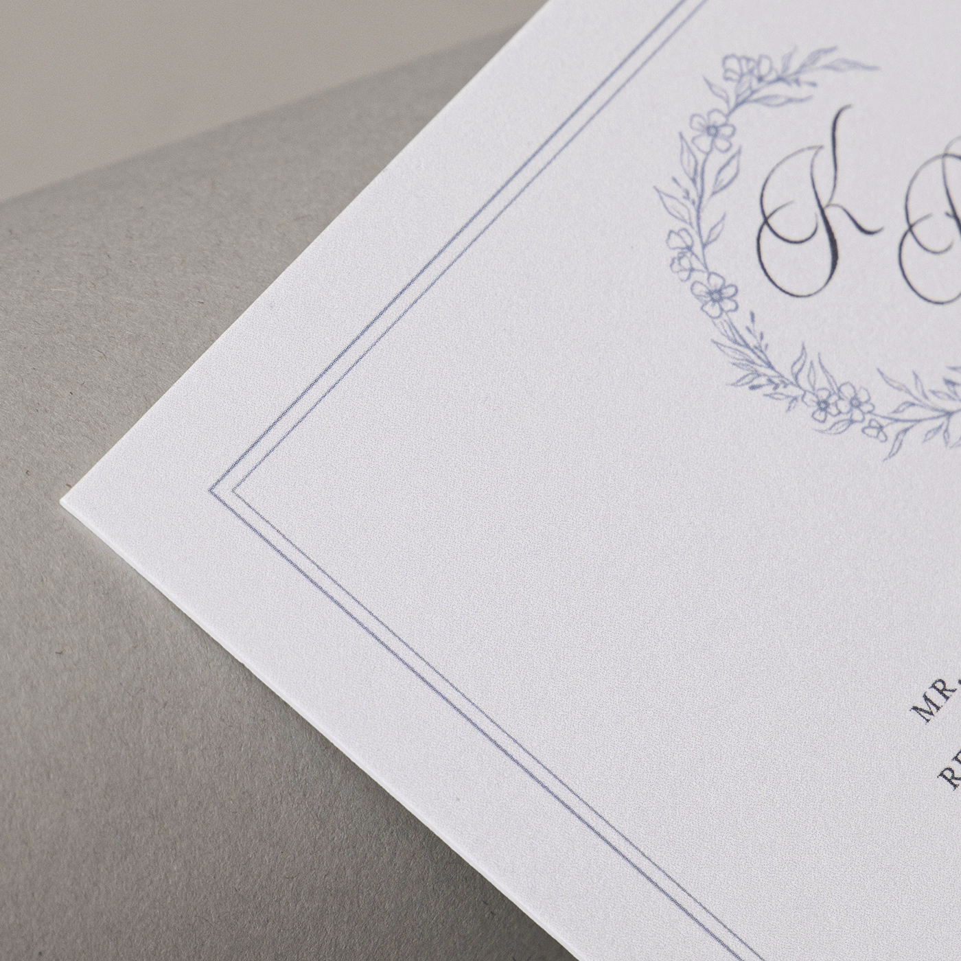 Close up image of white double thick paper, printed with a delicate blue design.