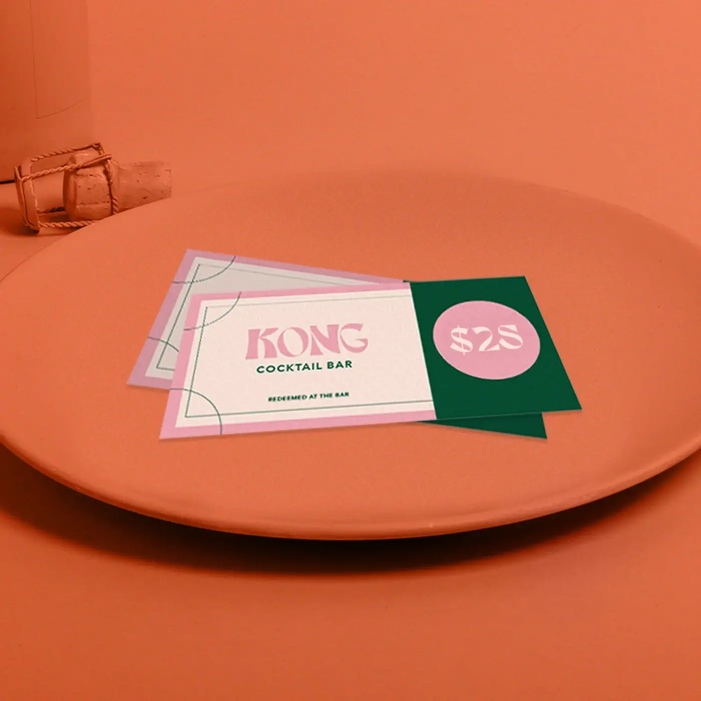 Two restaurant Gift Certificates with a pink and green design on an orange plate with an orange backround colour.