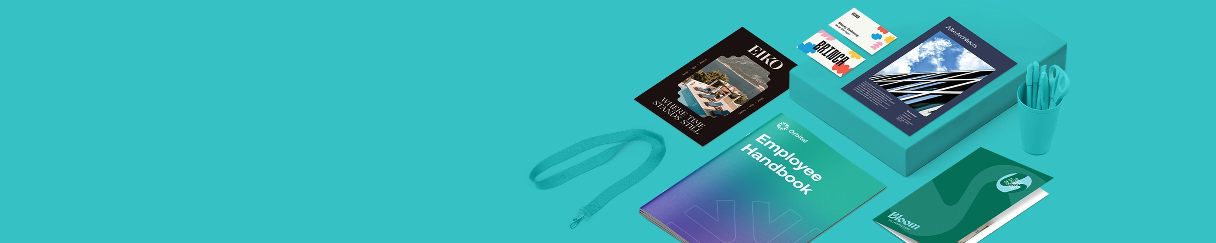An assortment of branded marketing materials, including an "Employee Handbook," various brochures, and business cards, is arranged on a teal surface alongside a cup of matching teal pens and scissors.