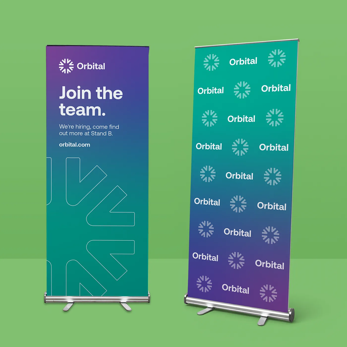 Two retractable banners displayed on a bright green background. The left banner is a "Join the team" recruitment sign for "Orbital" with a purple-to-teal gradient. The right banner is the teal-to-purple "Economy" version featuring the repeating "Orbital" brand logo pattern. Both banners are mounted in silver metal retractable bases.