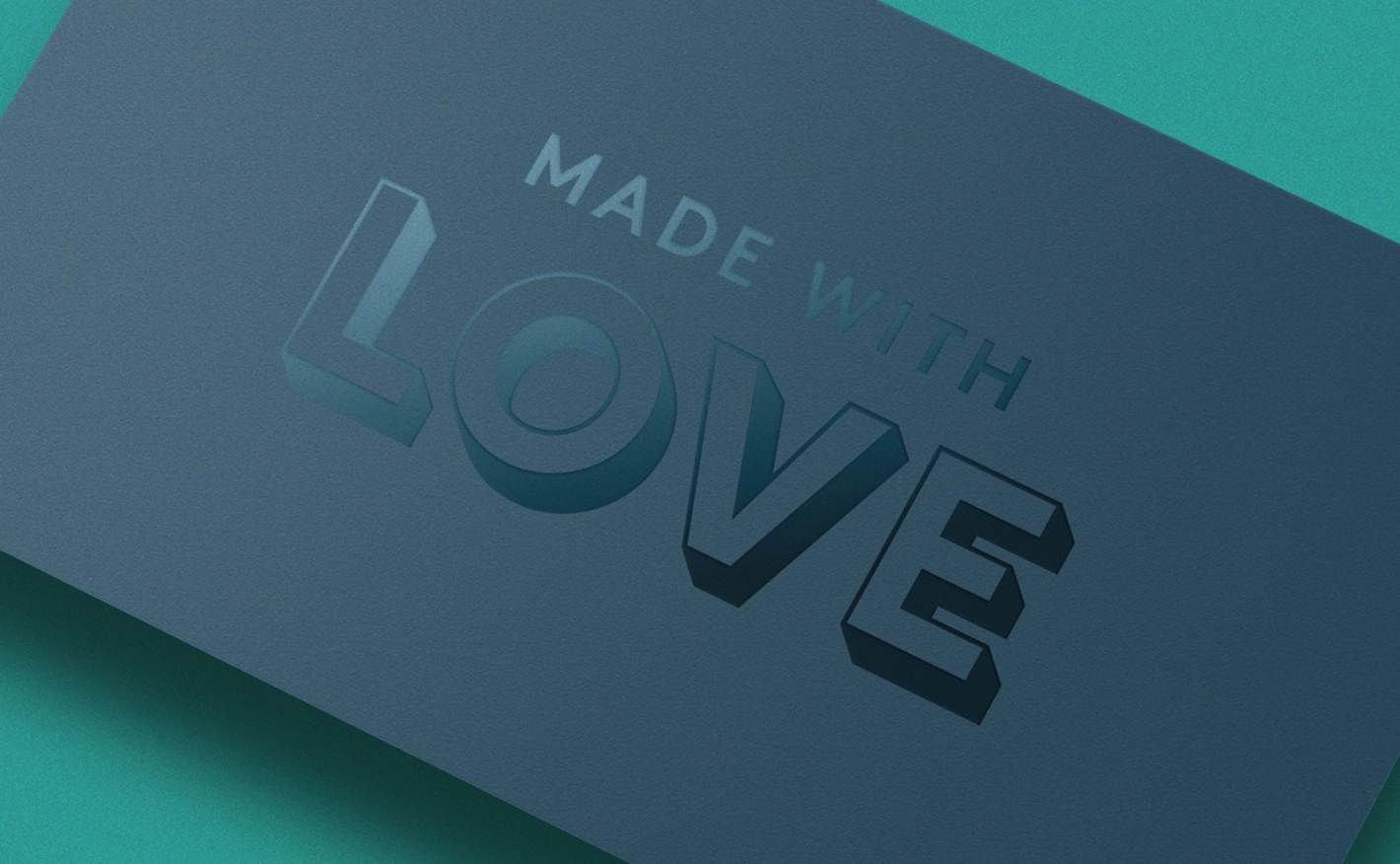 A close-up of a matte dark blue card displaying a clear, glossy spot UV finish. The glossy overlay spells out "MADE WITH LOVE" in a blocky 3D style, catching the light against the matte background.